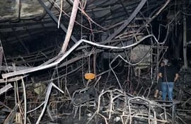 Unos hombres iraníes inspeccionan la escena del incendio que se ha provocado en un salón de bodas este miércoles en Hamndaniya, Irak, en el que han muerto más de 100 personas y, al menos, 150 han resultado heridas, durante la celebración de una boda cristiana. EFE/ Mohamad Saif