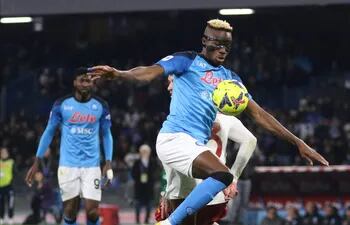 Víctor Osimhen, del Napoli, intenta controlar el balón ante la presencia de un jugador de Roma. El delantero nigeriano marcó ayer el primer gol para su equipo y es el máximo artillero de la Serie A.