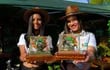 Las bellas señoritas Shirley Fiorella Miñaro y Belén Giménez sosteniendo los cofres con pepitas de oro que serán sorteados en el festival.