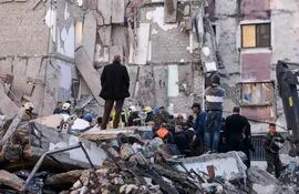 Trabajadores de rescate y civiles retiran los escombros de un edificio derrumbado en Thumana, Albania, este martes.