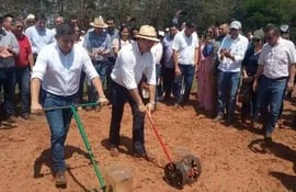 El ministro Carlos Giménez y el presidente de La Cámara de Exportadores de Sésamo Gilberto Ozorio realizan una siembra en una sembradora a mano simbólica en el predio del acto de lanzamiento
