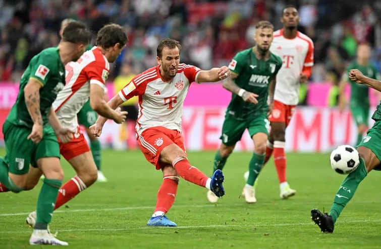 Harry Kane despide un potente remate de derecha hacia la portería del Augsburgo, durante el partido de ayer que el Bayern Munich ganó 3-1 gracias a un doblete del delantero internacional inglés.