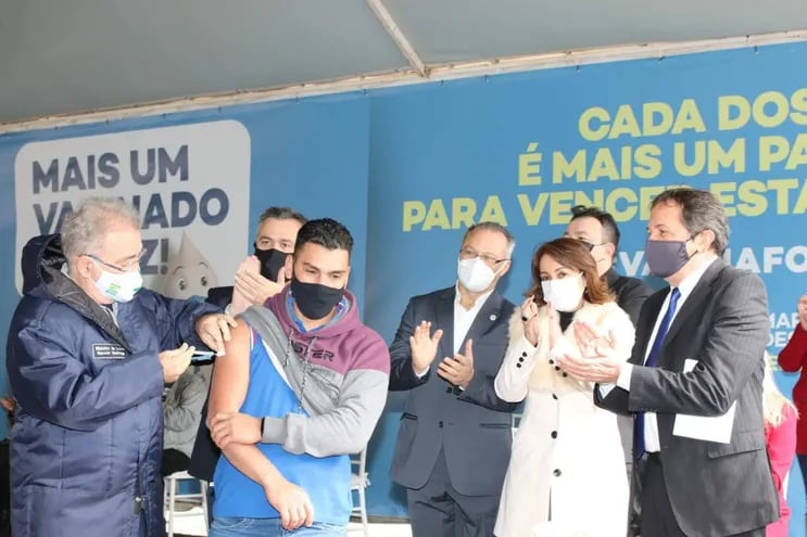 El ministro de Salud, Marcelo Queiroga, aplica una dosis contra el COVID-19 a un hombre durante su visita a Foz de Yguazú.