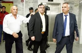 El diputado Tomás Rivas (centro) junto a su nuevo abogado Víctor Dante Gulino (d) retirándose de la suspendida audiencia preliminar.