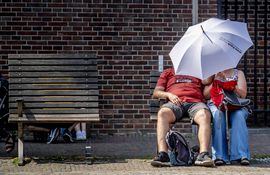 Una pareja se resguarda de los rayos de sol bajo un paraguas, este jueves en Ámsterdam (Holanda).
