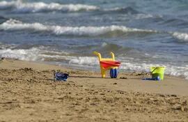 juguetes de playa en la arena frente al mar
