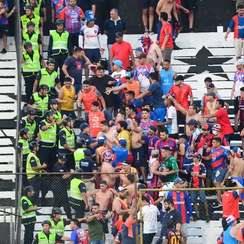 La barra brava del Club Cerro Porteño se enfrenta con la Policía durante el final del Clásico entre Cerro Porteño y Olimpia . EFE/ Daniel Piris
