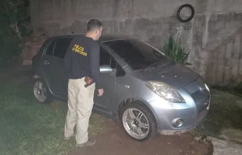 Un agente policial de Control de Automotores verifica el automóvil Toyota New Vitz gris oscuro que fue encontrado en una vivienda de J. Augusto Saldívar, semanas después de haber sido robado mediante un asalto en Itacurubí de la Cordillera.
