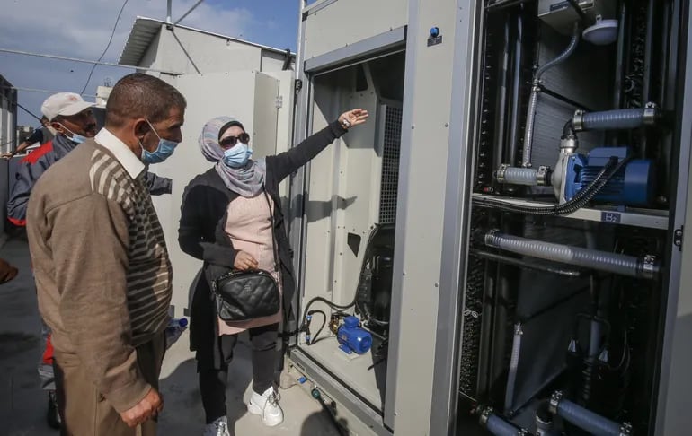 La ingeniera palestina Nadia Tubail verifica un generador de agua que funciona a energía solar y que extrae agua potable del aire.