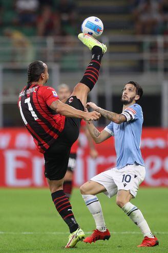 El suelo Zlatan Ibrahimovic, del AC Milan, extiende su pierna cuan largo es ante la presencia del español Luis Alberto, del Lazio, en un partido de la Serie A de Italia.