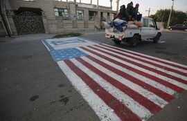 El 3 de enero de 2020 se pinta una simulacro de bandera de EE. UU. En el suelo para que los automóviles circulen en la capital iraquí de Bagdad, luego de la noticia del asesinato del comandante de la Guardia Revolucionaria iraní Qasem Soleimani en un ataque estadounidense contra su convoy en el aeropuerto internacional de Bagdad.