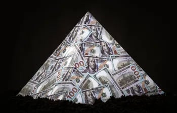 Una pirámide hecha con billetes de cien dólares, sobre un fondo negro.