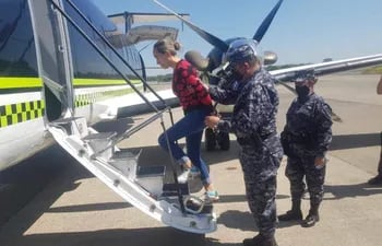 Policías salvadoreños suben  Margareth Lizeth Chacón Zúñiga al avión que la llevó a Colombia.