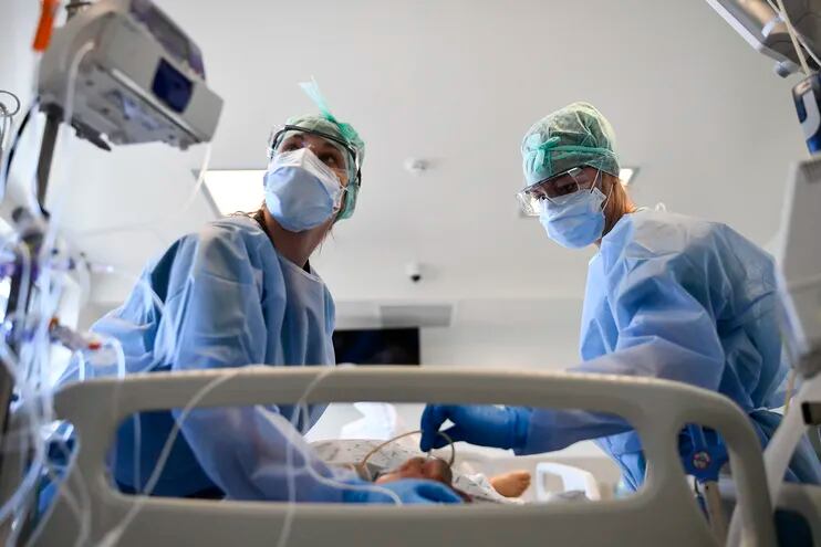 Members of the medical staff take care of a patient infected by Covid-19 at the Intensive Care Unit of the Etterbeek-Ixelles Hospital on April 6, 2021, in Brussels. (Photo by JOHN THYS / AFP)