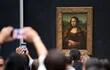 Visitantes del Museo del Louvre, en París, toman una foto de La Mona Lisa.