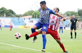 Aldo Barrientos, de 12 de Octubre, soporta la marca del capitán Óscar “Chipi”Jiménez, en la victoria de Ovetense 2-0 sobre el elenco de la Ciudad del Ñandutí. (Foto: Intermedia APF).