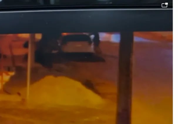 Gentileza. Captura de Video de circuito cerrado. Tres delincuentes se suben al auto blanco que luego se roban, dejando al dueño en la calle.