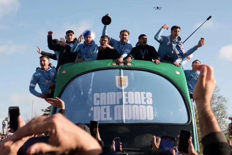 Jugadores de la selección uruguaya sub 20 festejan en un bus por las calles de Montevideo el título mundial de la categoría lograda el domingo pasado en Argentina.