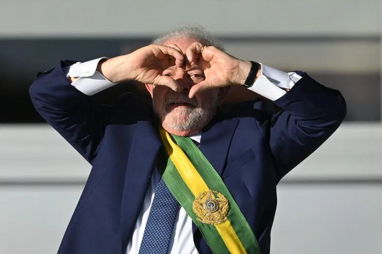 El nuevo presidente del Brasil Luiz Inacio Lula da Silva hace un corazón con las manos en dirección a sus seguidores, desde el palacio de Planalto, luego de tomar juramento.