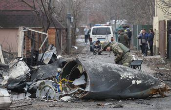 Un soldado observa los restos de un avión militar derribado durante la noche del 25 de febrero de 2022 en Kiev, Ucrania.