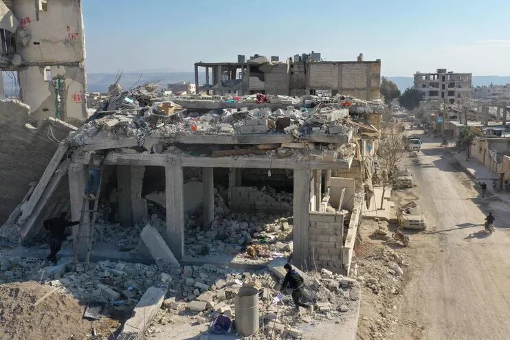 Una imagen aérea muestra a personas tratando de recuperar objetos de los escombros de un edificio derrumbado en la ciudad siria de Jindayris.