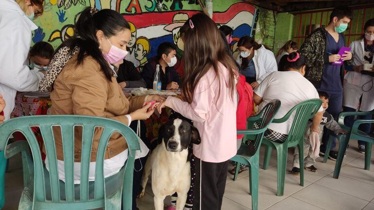 El perro Buquilla custodiando a las dos pequeñas y la madre, durante la jornada de atención médica en San Lorenzo.