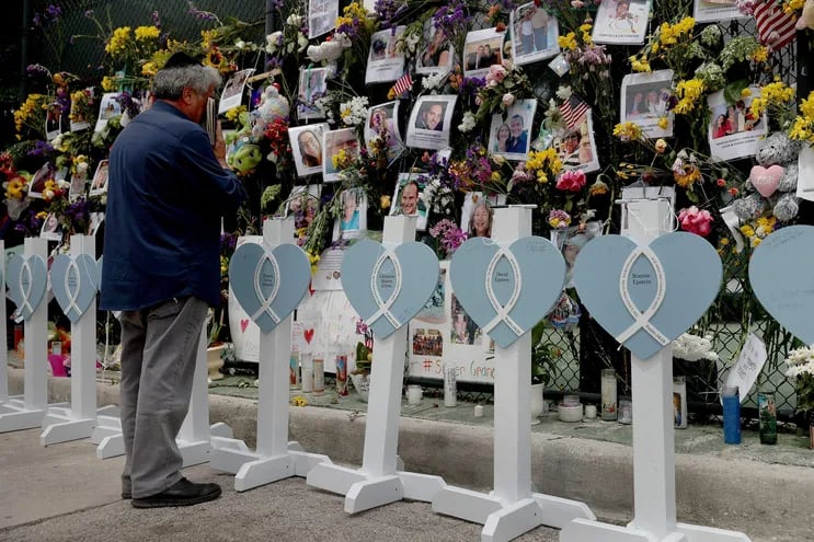 Un familiar observa el memorial instalado en honor a todas las víctimas del derrumbe del edificio en Miami.