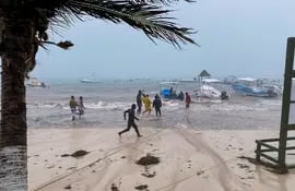 Los pescadores intentan proteger sus embarcaciones de las fuertes lluvias debido al paso de la Tormenta Gamma en Puerto Morelos, Estado de Quintanaroo, México.