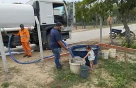 Desde un camión cisterna descargan el agua cruda tomada del río Paraguay para las familias de Carmelo Peralta, donde no logran solucionar la falta de sistema de suministro de agua potable.