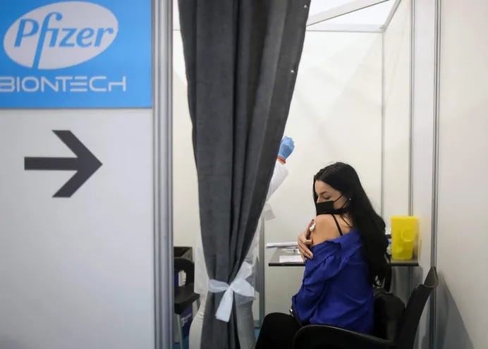Una mujer se presiona el brazo luego de haber recibido una dosis de la vacuna Pfizer contra el Covid-19 en Serbia.