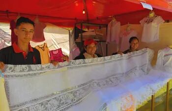 Los jovenes artesanos César Cristaldo, Gisella Godoy y Claudia Cardozo exhiben un mantel de ao po'i con encaje ju de 3 metros con 12 individuales, que tiene un costo de G. 1.300.000.