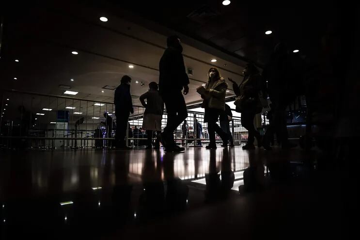 Personas con tapabocas caminan en el Aeropuerto Internacional de Ezeiza, en Buenos Aires (Argentina).