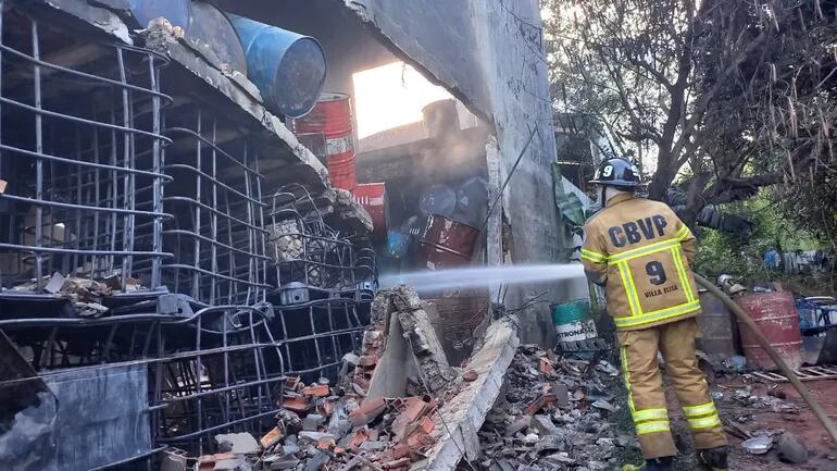 Bomberos de Villa Elisa realizan trabajo de enfriamiento ante avivamiento de llamas en depósito clandestino de combustible.