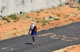 Fotografía de archivo del 16 de enero de 2017 de un preso que camina armado sobre un tramo de vía en el que se leen las siglas del Primer Comando Capital, durante un violento motín en la Penitenciaria Estatal de Alcaçuz, en Natal, en el estado de Río Grande do Norte, Brasil.
