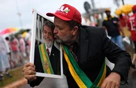 Un partidario besa un retrato del presidente electo Luiz Inacio Lula da Silva afuera del hotel donde se hospeda Lula en Brasilia.
