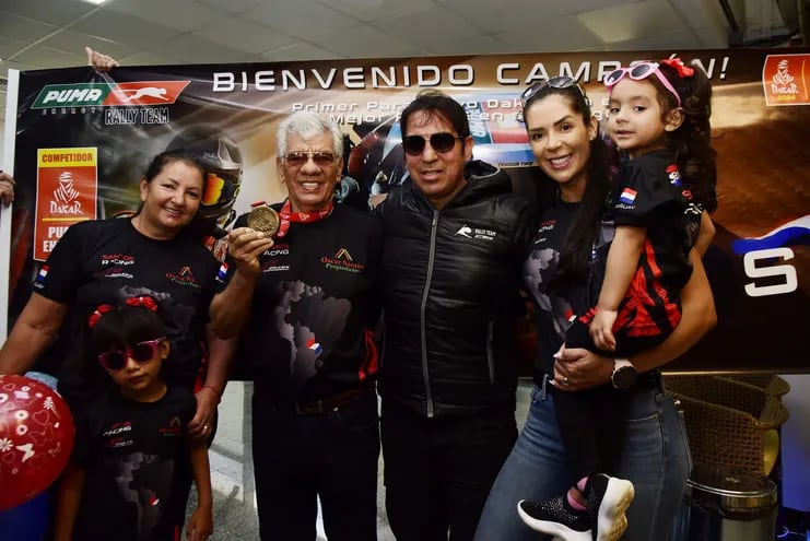 Óscar Santos con su familia ayer en el Aeropuerto Silvio Pettirossi tras su retorno.