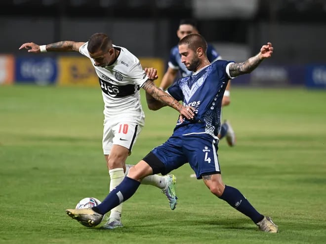 Derlis González (i), atacante de Olimpia, pelea el balón contra el defensor de Sportivo Ameliano en el partido de la séptima jornada del torneo Apertura 2022.