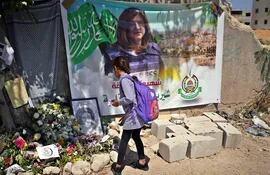 YENÍN, 27/05/2022.- Una niña deja flores junto a un retrato de la periodista de Al Yazira Shireen Abu Akleh, en Yenín, Cisjordania. EFE/ Sara Gómez Armas
