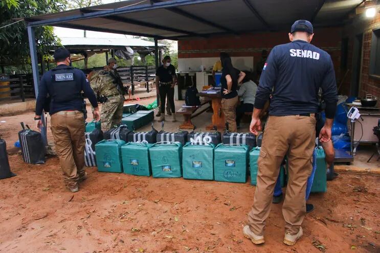 Agentes de la Senad y del Ministerio Público contabilizando los paquetes de cocaína hallados.