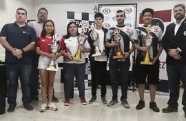 Los campeones del Nacional Absoluto y Femenino con sus trofeos junto a las autoridades de la Federación Paraguaya de Ajedrez.