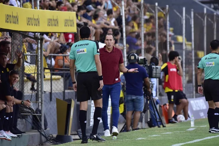 El entrenador de Guaraní, Lucas Bovaglio, pide explicaciones al cuarto árbitro tras la expulsión de Walter González.