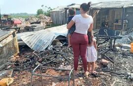 La madre y sus dos hijos observan lo que quedó de su casa, que fue totalmente consumida por el incendio ocurrido anoche.