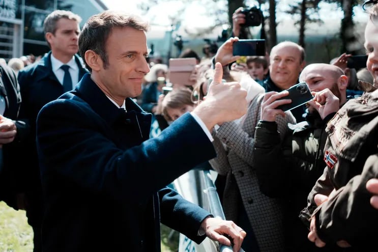 El presidente francés y candidato a la reelección, Emmanuel Macron, saluda a sus partidarios luego de depositar su voto.