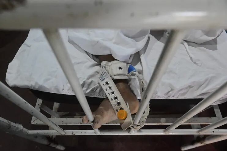 Un paciente, amarrado a su cama en el Hospital Psiquiátrico.