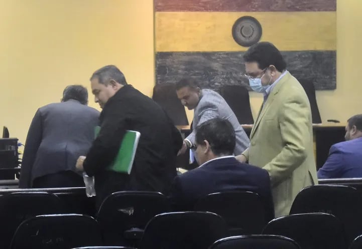 El diputado Rubén Roussillón (con carpeta en verde) y José Ortiz, expresidente de Conajzar, se presentaron esta mañana en la audiencia preliminar ante el juez Humberto Otazú. La diligencia continua mañana.