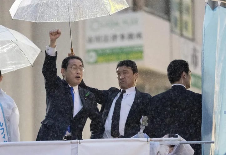 El primer ministro japonés Fumio Kishida (izquierda), custodiado por agentes de seguridad, dando un discurso de campaña durante un evento de campaña en la estación Motoyawata en Ichikawa, Prefectura de Chiba, al este de Tokio, Japón.