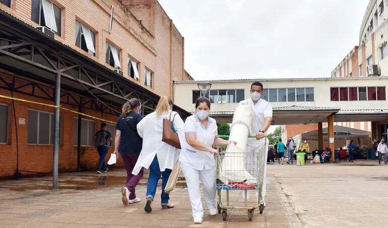 Personal de blanco del Hospital de Clínicas corriendo por los pasillos del nosocomio con balones de oxígeno tras la caída del servicio.