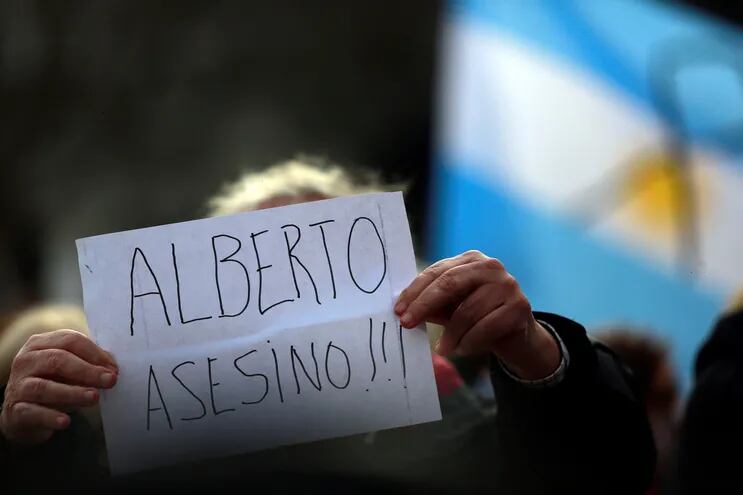 Una persona muestra un cartel contra el presidente Alberto Fernández durante una manifestación contra su Gobierno por el manejo de la pandemia  y en memoria de los fallecidos por coronavirus, frente a la Casa Rosada, en Buenos Aires (Argentina).