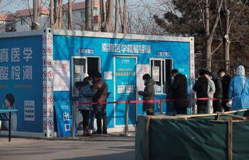 Personas con mascarillas forman fila para realizarse la prueba de la enfermedad covid-19 en el subdistrito de Shangdi en Haidian, Pekín, China. En la capital china, universitarios protestan contra las restricciones.