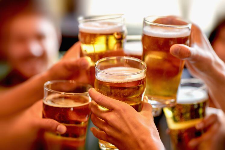 ¡Chin-chin! Un brindis con cerveza entre amigos. En las casas se puede tomar alcohol hoy, pero desde las 19 está prohibida la venta y el expendio.